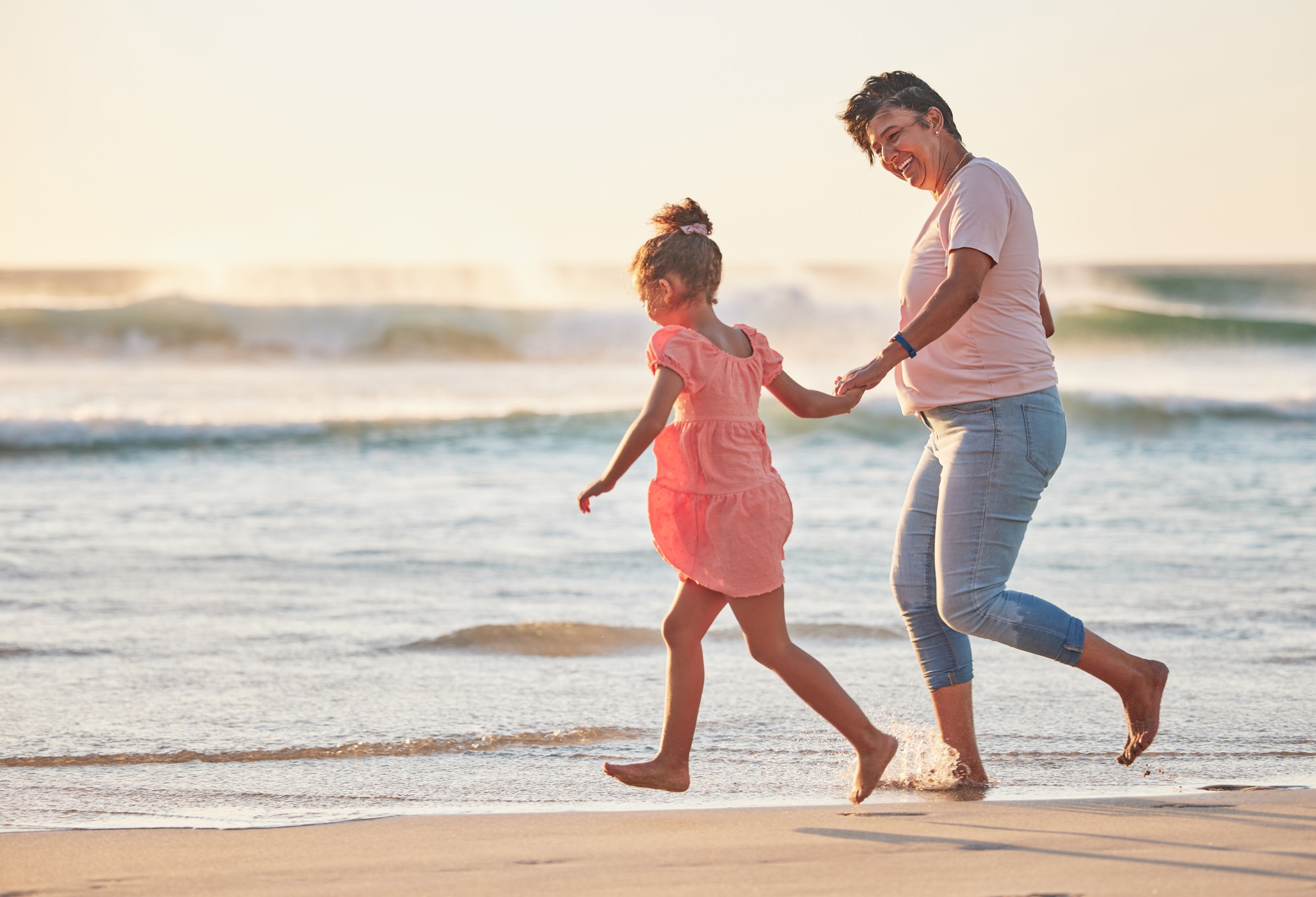 Family, child and grandma running on beach vacation having fun, energy and adventure with mature an