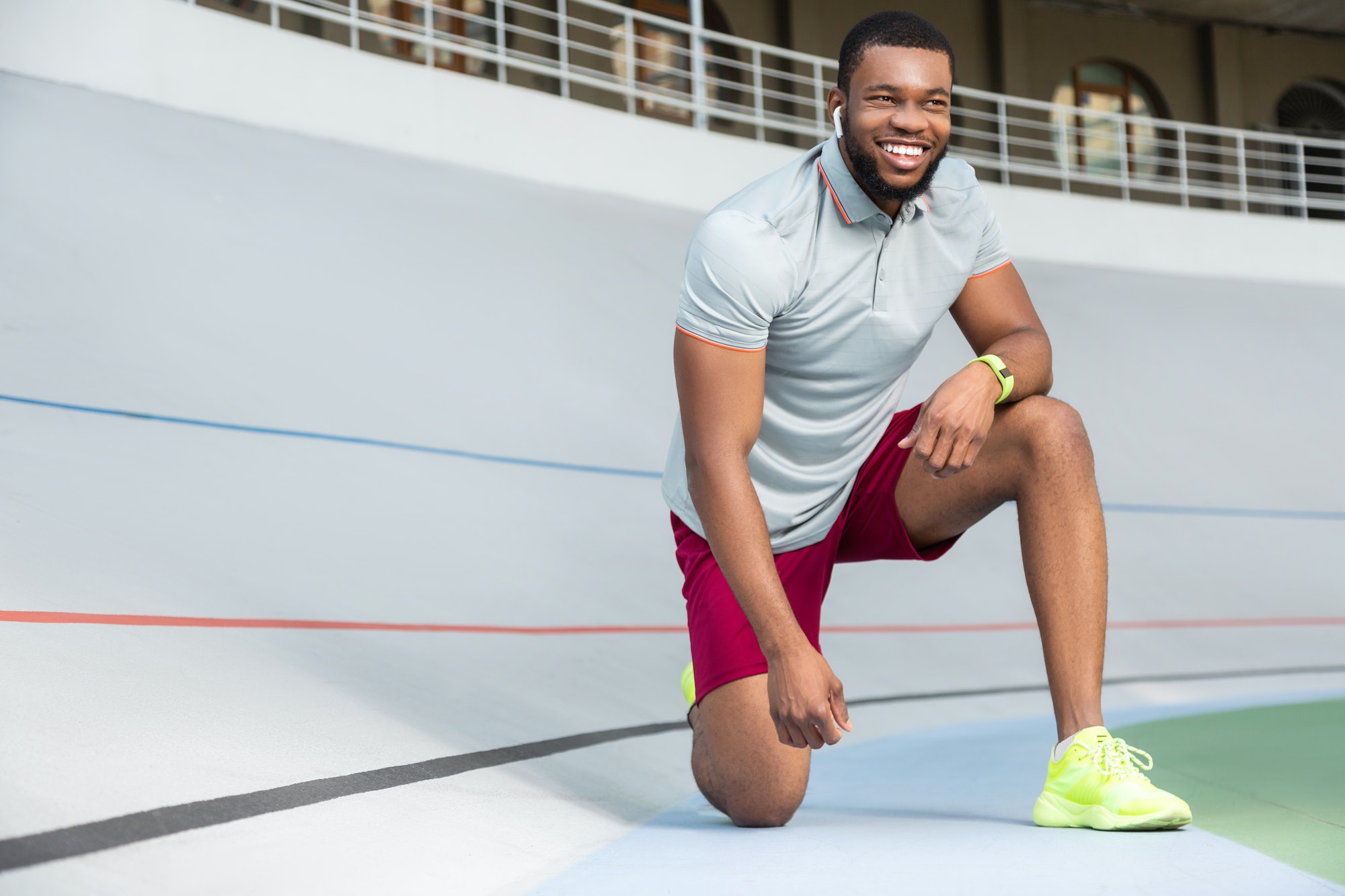 Handsome young male runner standing on one knee